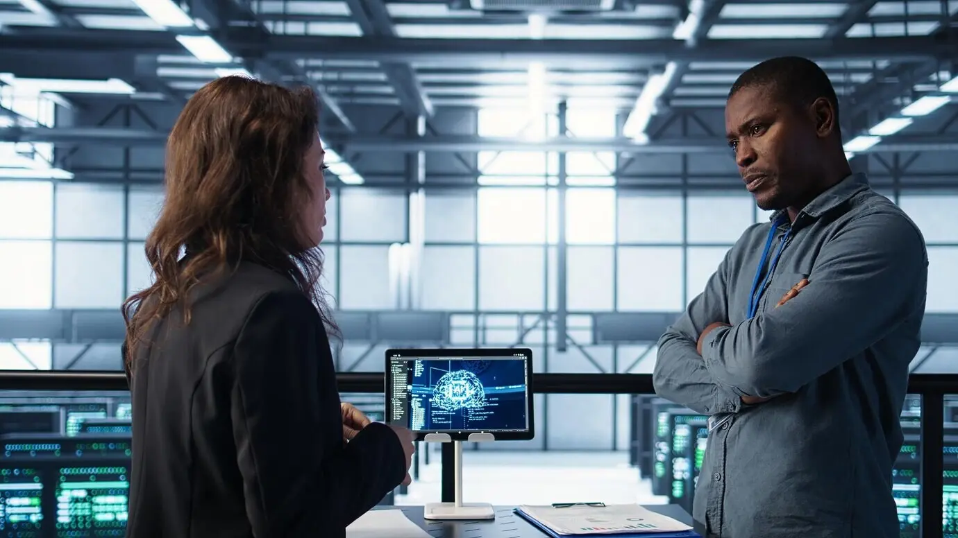 Команда инженеров в дата-центре с планшетом, интегрирующая инструменты ИИ-автоматизации.